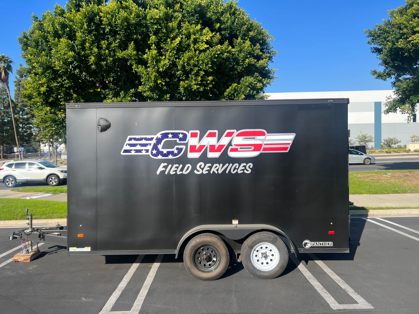 Side of a black CWS enclosed cargo trailer: stars-and-stripes 'CWS Field Services' vinyl logo and lettering across the panel, installed by Hi Sign, Brea, CA