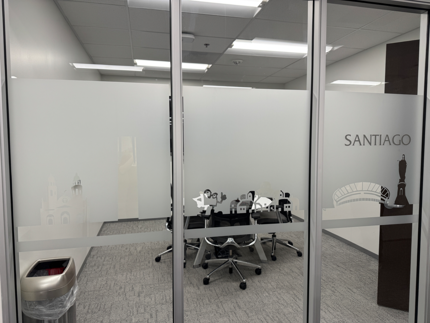Glass office wall with a frosted privacy band carrying a cut-vinyl skyline and the room name SANTIAGO, installed by Hi Sign, Brea, CA