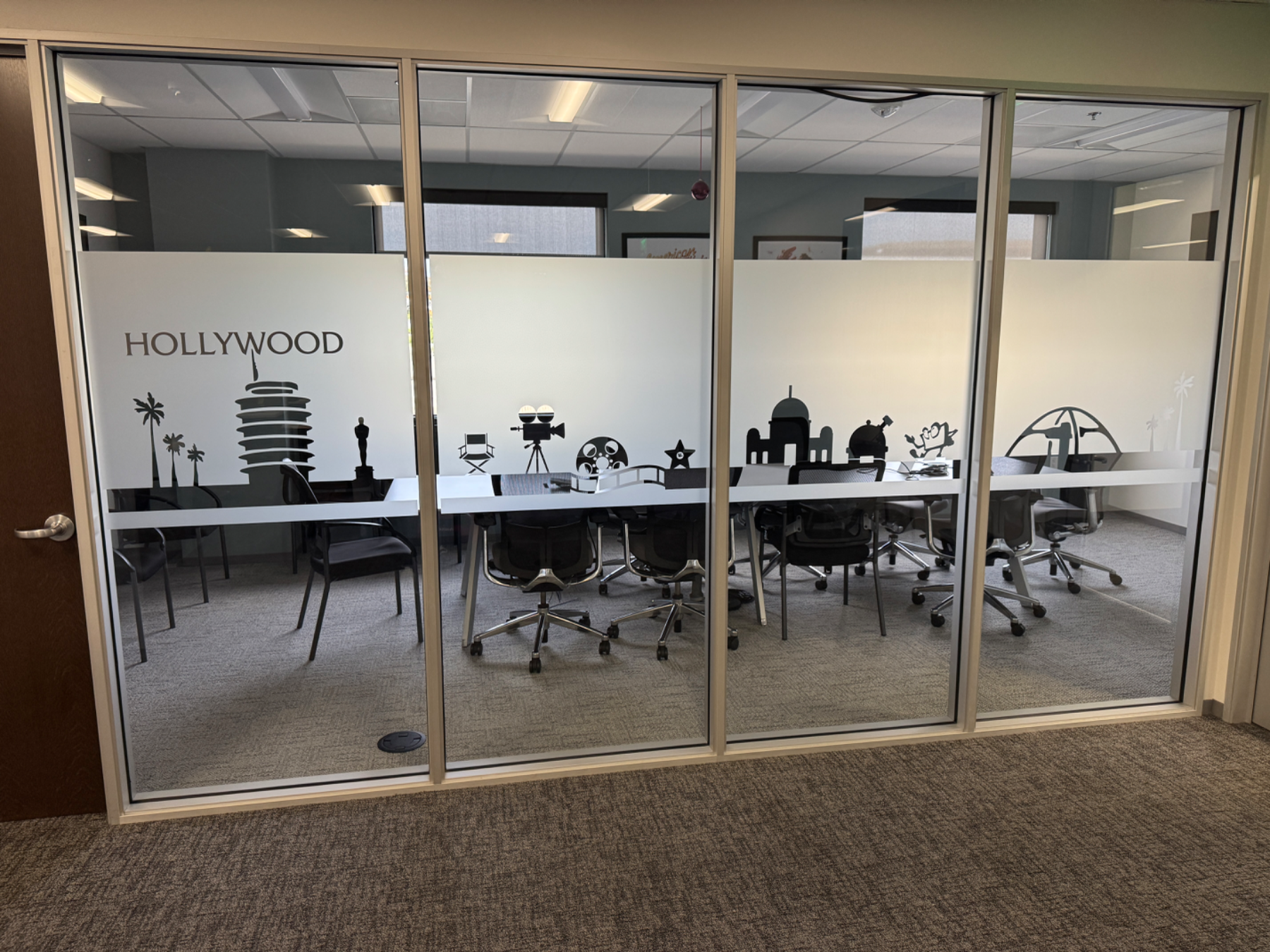 Glass meeting room wall with a frosted band carrying a cut-vinyl Hollywood skyline and the room name HOLLYWOOD, installed by Hi Sign, Brea, CA