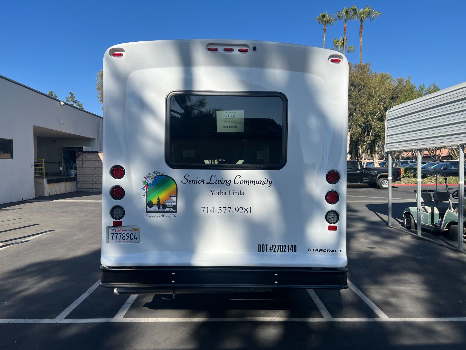Rear of the same Starcraft shuttle bus: vinyl lettering, rainbow star logo, phone number, and DOT number applied to the rear body panel, installed by Hi Sign, Brea, CA