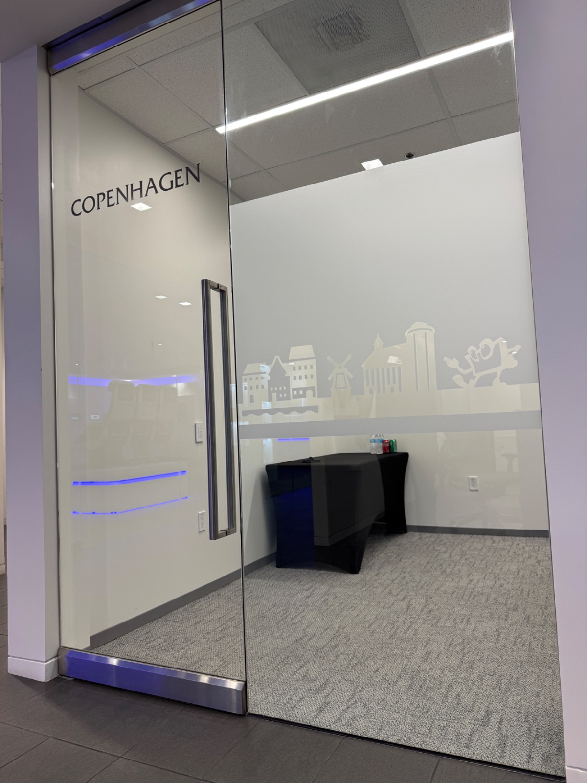 Frosted glass office room front with a cut-vinyl Copenhagen skyline and the room name COPENHAGEN, installed by Hi Sign, Brea, CA