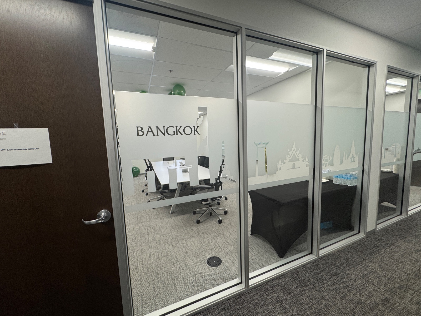 Bangkok meeting room seen from the corridor door side, frosted band and cut-vinyl skyline running the length of the glass, installed by Hi Sign, Brea, CA