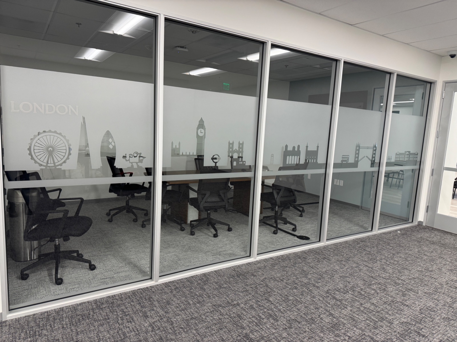 London room glass photographed straight on, frosted band carrying a Ferris wheel, Big Ben and Parliament silhouettes, installed by Hi Sign, Brea, CA