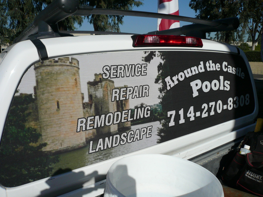 Rear window of a white pickup truck covered with a see-through perforated vinyl graphic for Around the Castle Pools listing service, repair, remodeling, and landscape with a phone number, installed by Hi Sign, Brea, CA